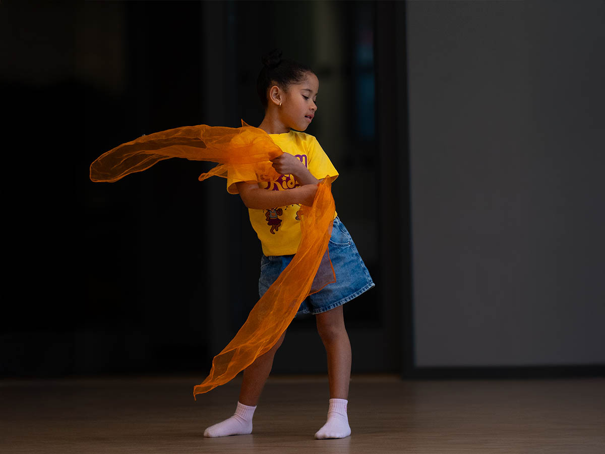 Flicka dansar med orange scarf på FunkyKidz