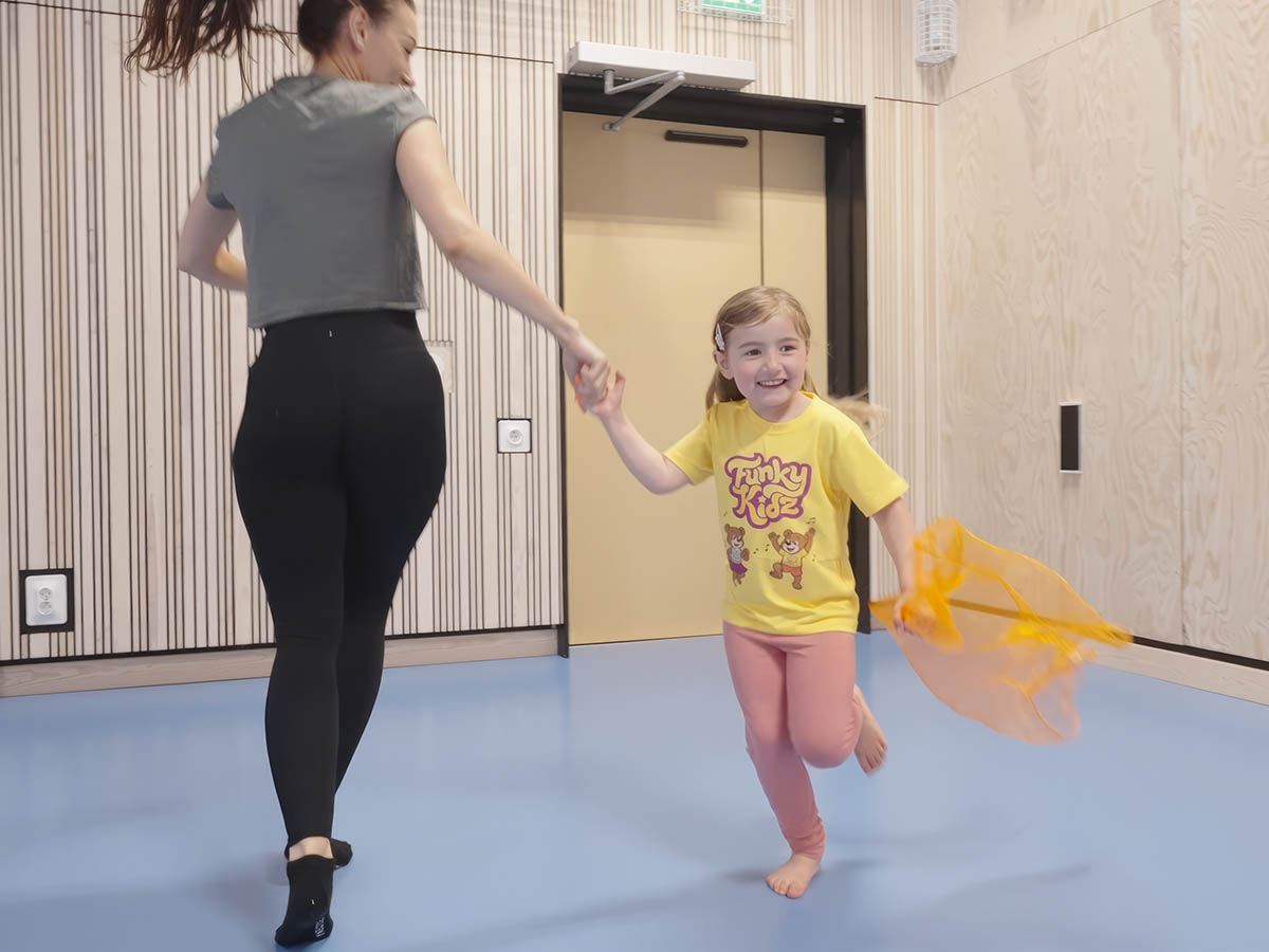 Barn och förälder dansar tillsammans med ett tygsjal.