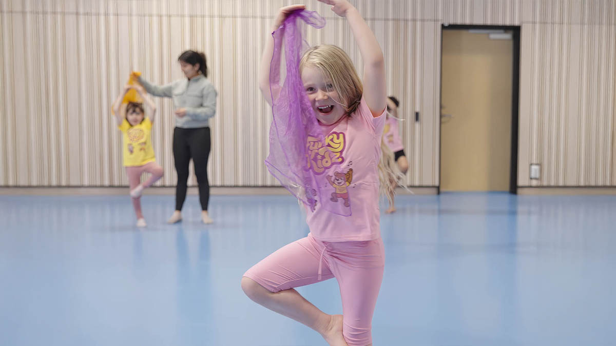 Barn dansar och viftar med lila danssjal.