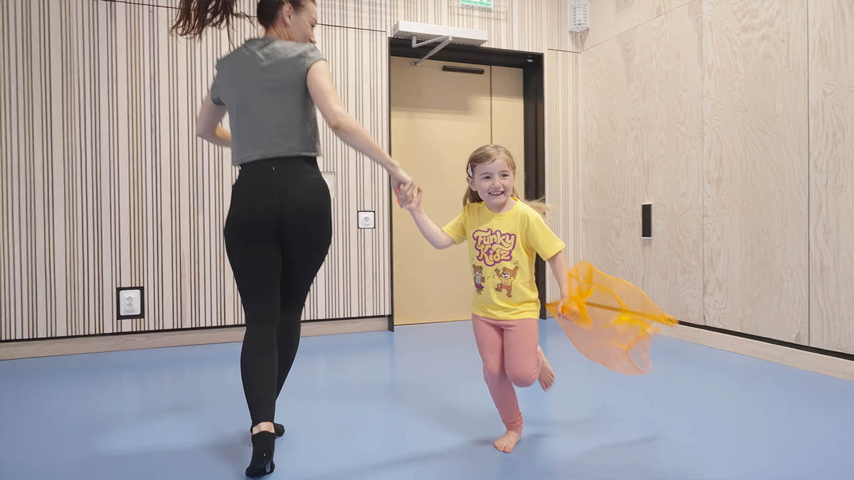 Barn och förälder dansar tillsammans med ett tygsjal.