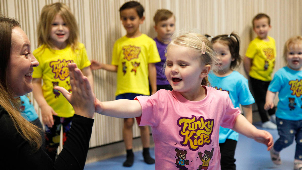 Barn ger ledare high five på FunkyKidz danskurs